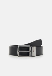 Cintura in pelle nera con una fibbia in metallo argentato lucido, caratterizzata da una forma rettangolare semplice e una superficie liscia e opaca.