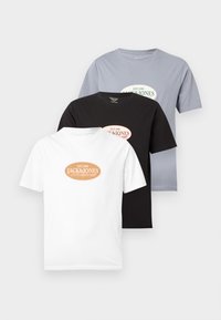 Τρία διπλωμένα μπλουζάκια Jack & Jones σε λευκό, μαύρο και ανοιχτό γκρι με οβάλ λογότυπα τυπωμένα στο κέντρο του στήθους.
