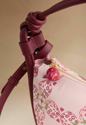 Lyserød og mørkerød skuldertaske med jordbærmønstre, knyttet mørkerød strop og lynlås træk formet som en rød mariehøne med rhinsten.