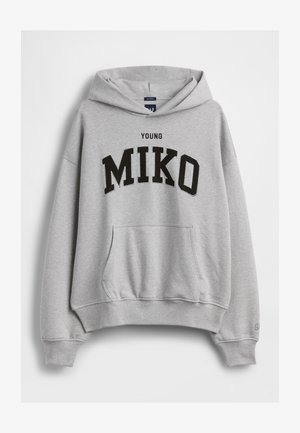 Ανοιχτογρίζο φούτερ με μπροστινή τσέπη και κουκούλα, με μαύρο κείμενο "YOUNG MIKO" στο κέντρο του στήθους.