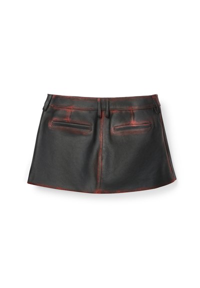 Minigonna in pelle nera con dettagli rossi consumati, passanti per cintura e due tasche orizzontali posteriori, mostrata distesa su sfondo bianco.
