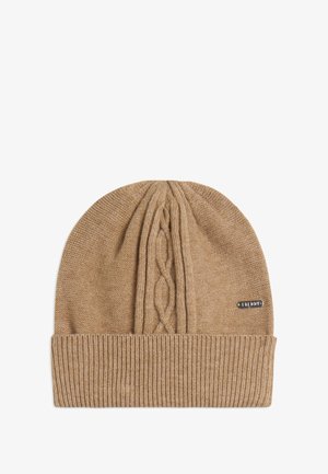 Bonnet en tricot marron clair avec un motif en relief de câble sur le dessus et un bord côtelé en bas. Étiquette sur le côté.