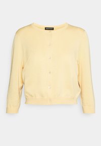 Gul strikket cardigan med rund halsudskæring, frontknaplukning og trekvartærmer. Glat tekstur og ribbet kantdetalje.