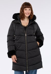 Schwarze Daunenjacke mit Kapuze, ausgestattet mit einem Reißverschluss vorne, Seitentaschen und Fäustlingen aus Kunstpelz. Strukturierter, gesteppter Design mit glänzender Oberfläche.