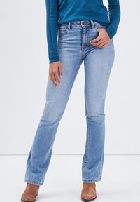 Jasnoniebieskie dżinsy w fasonie dzwonów z denimu, z średnim stanem, z delikatnym wyblaknięciem, pięcioma kieszeniami i klasycznym zapięciem na guzik.