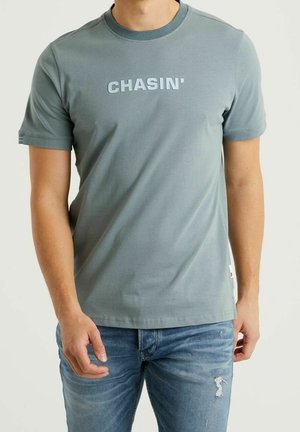 Szara koszulka z krótkim rękawem i okrągłym dekoltem, z jasnoniebieskim napisem "CHASIN'" na przodzie. Wykonana z miękkiego materiału o gładkiej fakturze.