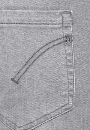 Tasca posteriore dei jeans in denim grigio con doppia cucitura curva e un piccolo emblema metallico a forma di lettera "D" nell'angolo in alto a destra.