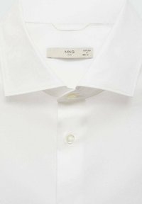 Biała koszula z guzikami i klasycznym kołnierzykiem, z pojedynczym zapięciem na guzik oraz metką oznaczającą rozmiar M (EU/USA) od marki MNG.