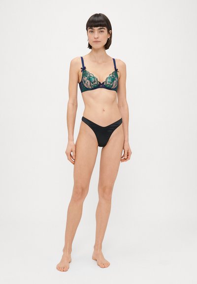 Pitsimallinen pitsibrassi vihreällä kukkakuviolla, laivaston siniset hihnat ja nauhadetaili. Mustat korkeavyötäröiset alushousut. Sileä pinta, jossa on läpikuultavia kohtia.