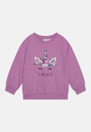 Lila Sweatshirt mit einem Einhornmotiv und floralen Akzenten sowie dem Schriftzug "Be Magical" in Glitzer. Gerippte Bündchen und Saum.
