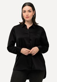 Camicia nera in satin a maniche lunghe con bottoni. Presenta un collo classico, una placca frontale e un orlo arrotondato con spacchi laterali.