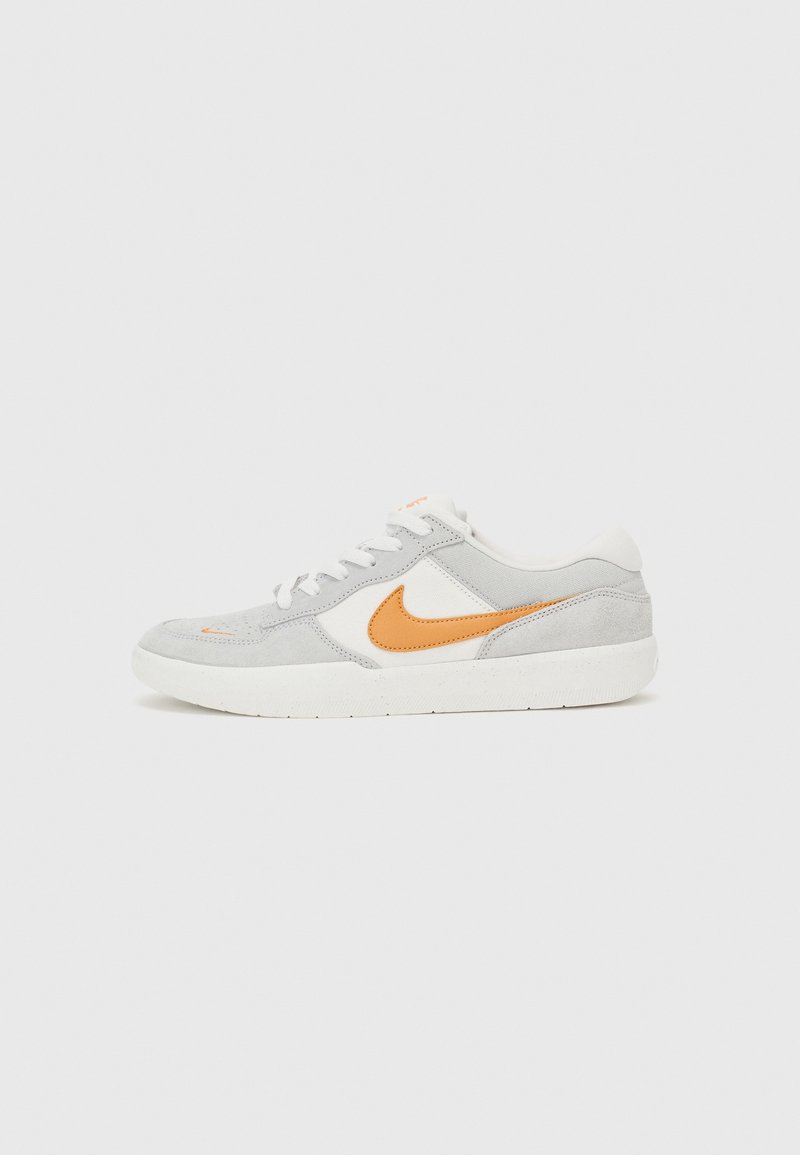 Matala harmaa ja valkoinen lenkkari, jossa on oranssi Nike-tikkuma ja valkoiset nauhat, esillä tasaisella valkoisella taustalla.