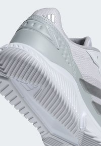 Svetlosivá športová obuv s textúrovaným sieťovinovým zvrškom, hladkými syntetickými detailmi a hrubou, ryhovanou bielou gumovou podrážkou. Obsahuje reflexné prvky.