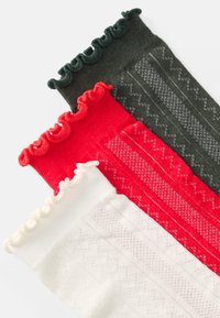 Conjunto de tres medias hasta la rodilla: verde oscuro, rojo y blanco. Cada una tiene un borde fruncido y una textura con patrones y diseños sutiles en colores contrastantes.