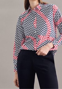 Knapp-up skjorta med ett geometriskt mönster av röd, marinblå och vit fiskbensväv och ränder. Långa ärmar, krage och en avslappnad passform.