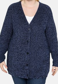 Marinblå stickad cardigan med V-hals, långa ärmar och sex svarta knappar framtill. Mjuk textur med ett blandat mönster.
