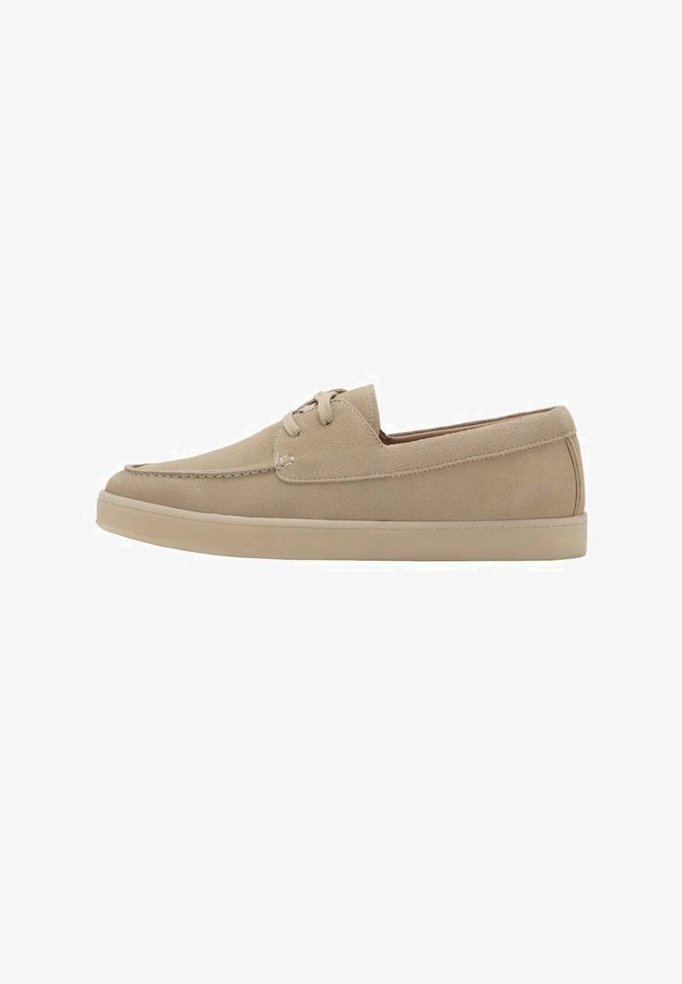 Beige suède casual schoen met veters, mocassin-achtige stiknaden en een vlakke rubberen zool, zij-aanzicht op witte achtergrond.