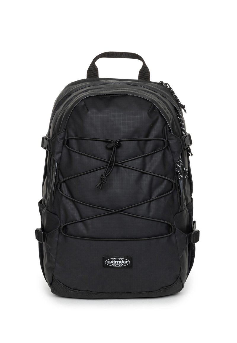 Zaino nero con un design elegante in nylon, parte superiore curva, cordino anteriore regolabile, tasche laterali e logo Eastpak nella parte inferiore.