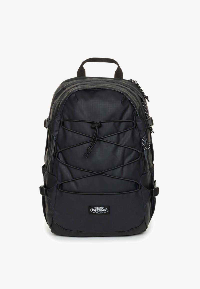 Zaino nero con un design elegante in nylon, parte superiore curva, cordino anteriore regolabile, tasche laterali e logo Eastpak nella parte inferiore.