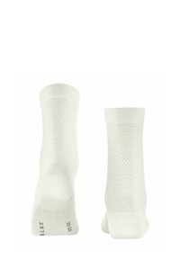 Chaussettes blanches avec un motif en chevrons, des poignets côtelés et une texture lisse. Présentent une semelle renforcée et un branding subtil sur le dessous.