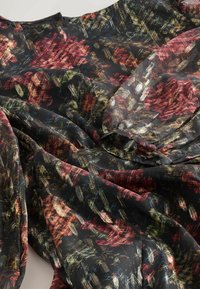 Schwarzer transparenter Stoff mit einem farbenfrohen abstrakten Muster in Rot-, Grün- und Blautönen, das subtile Texturen und ein fließendes Design aufweist.
