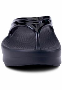 Black flip-flops with a glossy strap, textured footbed, and lightweight sole, featuring an open-toe design and minimalistic shape.