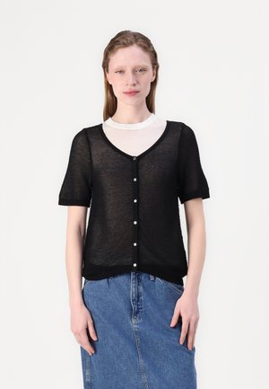 Black knit cardigan with short sleeves, featuring a v-neckline, five button closures, and ribbed hem, layered over a white shirt.
