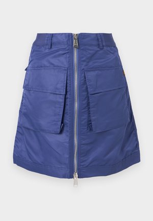 Marineblå kjol i nylon med dragkedja fram. Har två stora instickfickor och en strukturerad silhuett. Slät textur.