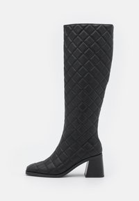 Bottes noires montantes avec un design texturé matelassé, bout carré et talon bloc. Fabriquées en matériau synthétique avec une finition lisse.
