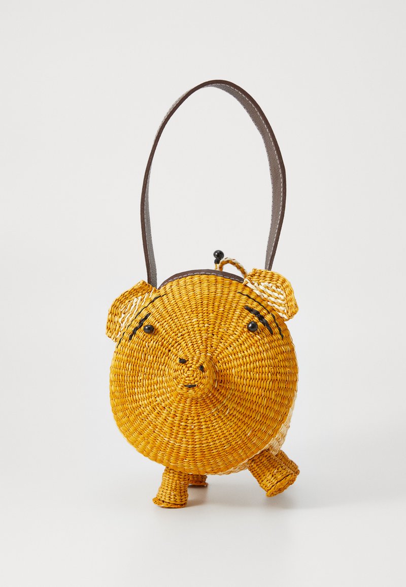 Round, yellow woven straw bag designed as a pig with black bead eyes and a brown strap. Features four short legs and a curved snout.