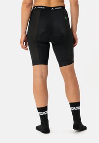 Shorts da ciclismo neri con imbottitura, pannelli laterali in rete e design aderente. Presentano una vita con logo e dettagli testurizzati.
