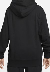 Czarna bluza z kapturem wykonana z miękkiego materiału. Posiada przestronny kaptur i luźny krój z prążkowanymi mankietami oraz dolnym ściągaczem. Minimalistyczny design bez widocznych logo.