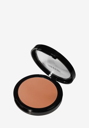 Bronzer w pudrze w okrągłym czarnym opakowaniu z przezroczystą pokrywką. Gładka, matowa tekstura; ciepły odcień tan. Kompaktowy design ułatwiający przenoszenie.