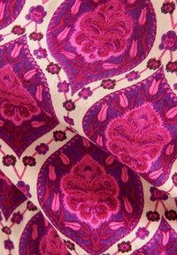 Wzorzysta tkanina z motywem paisley w odcieniach różu i fioletu, z kremowymi akcentami i kwiatowymi wzorami. Gładka tekstura.