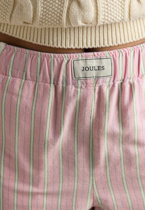 Pohľad na pás ružových pruhovaných nohavíc s elastickým pásom a značkovou etikietou Joules, v kombinácii s krémovým pleteným sveterom.