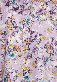 Camicia button-up lilla con motivo floreale, caratterizzata da fiori bianchi, gialli e viola, tessuto testurizzato e taschino sul petto.