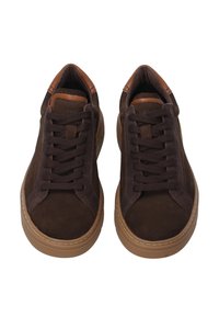 Pár tmavě hnědých casual tenisek se sladěnými tkaničkami a světle hnědými gumovými podrážkami, zobrazené shora na bílém pozadí.
