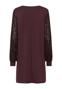 Abito bordeaux con maniche lunghe; corpo a maglione morbido e maniche decorate da paillettes con texture. Presenta un coltondo e una vestibilità rilassata. Orlo semplice.