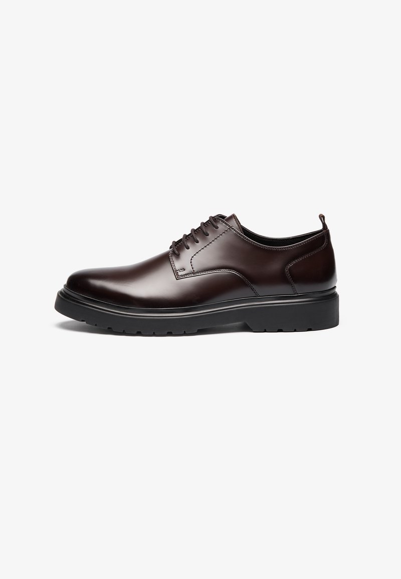 Brown leather lace-up shoe with a sleek design, round toe, contrasting black rubber sole, and minimal visible stitching.