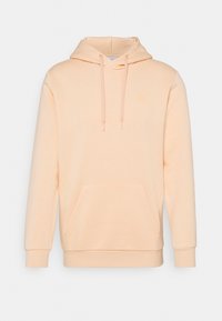 Persikofärgad hoodie tillverkad av mjukt tyg, med en känguruficka, snoddhuva och ribbad ärmavslut. Enkel design med minimal detaljer.