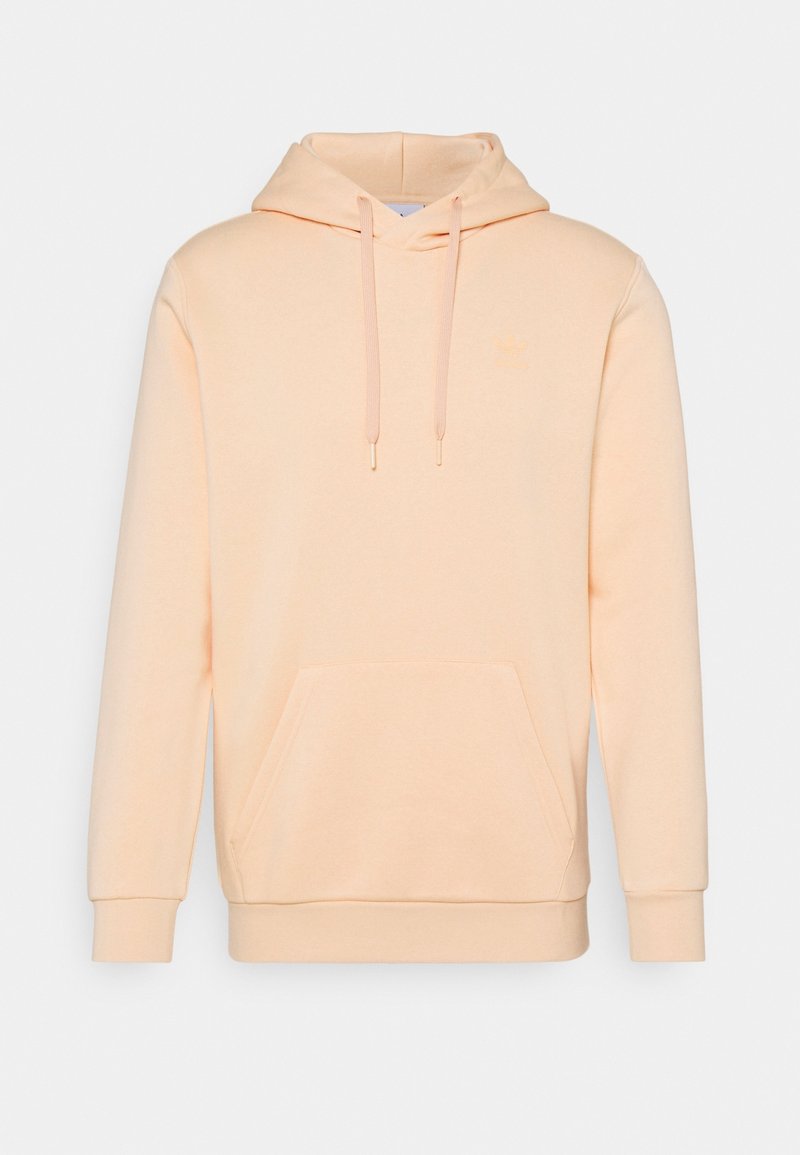 Persikofärgad hoodie tillverkad av mjukt tyg, med en känguruficka, snoddhuva och ribbad ärmavslut. Enkel design med minimal detaljer.