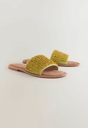 Sandale verzi cu talpă texturată, având un model împletit. Înălțimea bej moale și talpa exterioară de un maro deschis. Design cu vârf deschis.