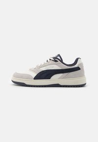 Sneaker bianco e blu navy con una combinazione di pelle e camoscio, punta rotonda, superficie testurizzata e strisce a contrasto. Suola in gomma con presa.