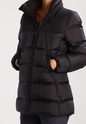 Black puffer jacket with a high collar, zippered front, and buttoned pockets. Made of smooth, shiny material with quilted sections.