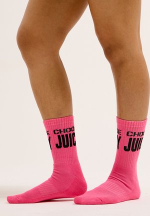 Rosa gerippte Socken mit einem schwarzen Druck, der rund um den oberen Rand "CHOOSE JUICY" liest. Weicher Stoff mit einem Crew-Länge-Design.