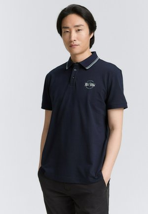 Marine polo shirt met een gestreepte kraag, voorzien van een klein geborduurd logo aan de linkerkant. Gemaakt van een gladde stof, met korte mouwen.