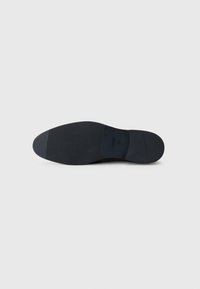Semelle d'une chaussure habillée pour homme en cuir noir, avec des zones de grip texturées et la taille 43 imprimée près du centre.