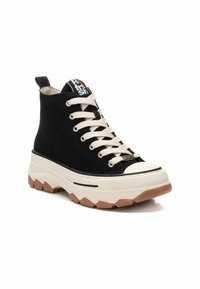Sneaker alte nere con tomaia in tessuto texturizzato, lacci bianchi, suola in gomma spessa e un logo sulla linguetta.