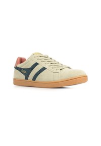 Beige suède sneaker met marineblauwe strepen, bruine accenten en een rubberen zool. Beschikt over een vetersluiting en een klein logo-detail aan de zijkant.
