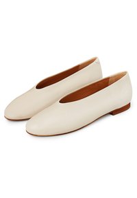 Ballerine in pelle crema con punta arrotondata, tacco basso e superficie liscia; presenta un design minimalista senza decorazioni.